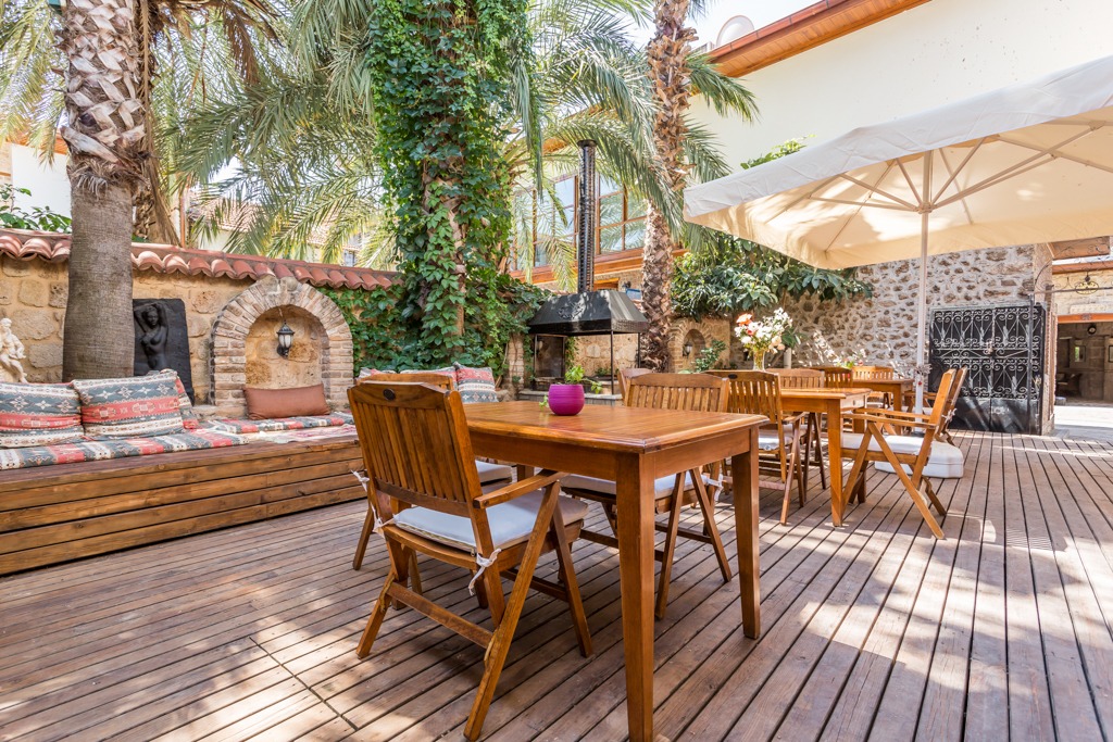 Wooden work tables and palms in the GYC House courtyard in Kaleiçi, Antalya.